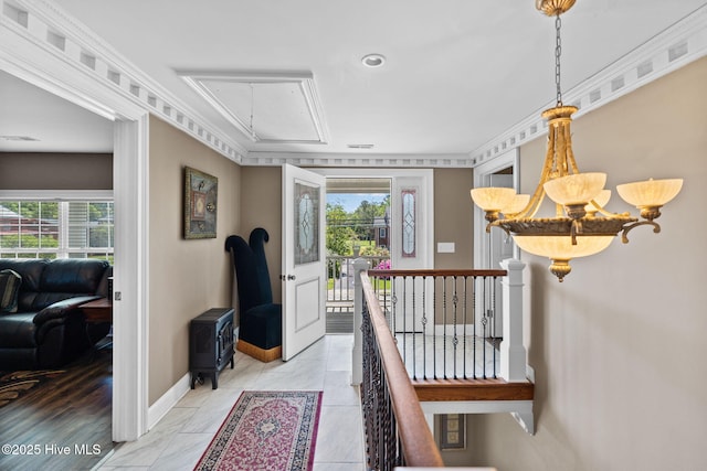 hall featuring baseboards, attic access, an upstairs landing, and plenty of natural light