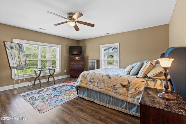 bedroom with wood finished floors, visible vents, and baseboards