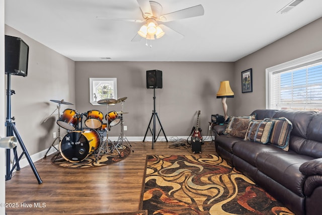 living room featuring visible vents, wood finished floors, ceiling fan, and plenty of natural light