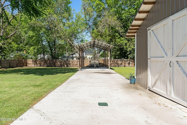 exterior space with a patio area, an outdoor structure, a fenced backyard, a carport, and driveway