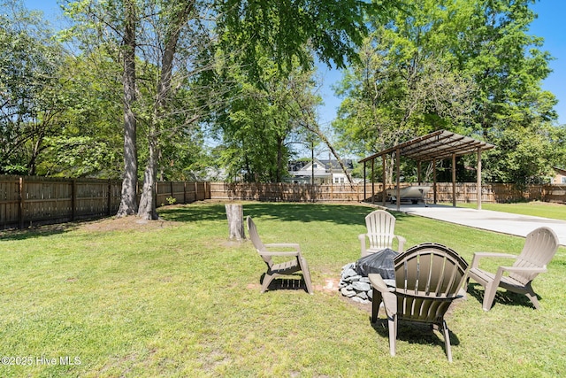 view of yard featuring a fire pit, a fenced backyard, a detached carport, and a pergola