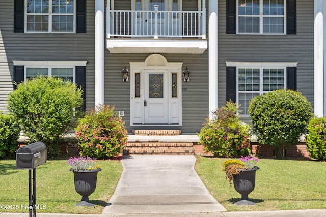 doorway to property with a yard and a balcony