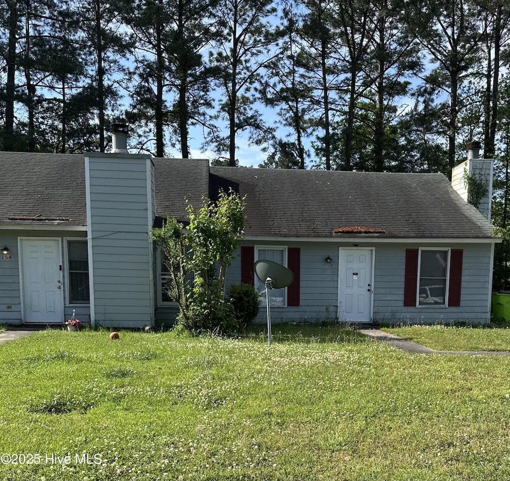 view of front of property featuring a front yard and a chimney