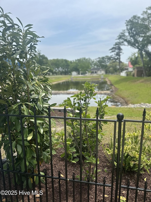 view of gate featuring a water view and fence