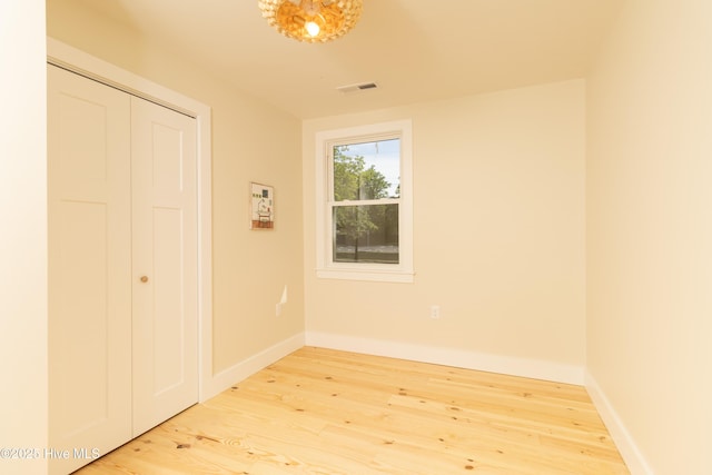 unfurnished bedroom with wood finished floors, a closet, and baseboards