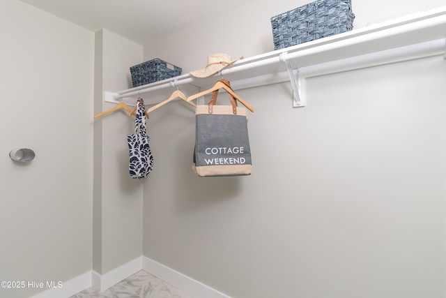 spacious closet featuring marble finish floor