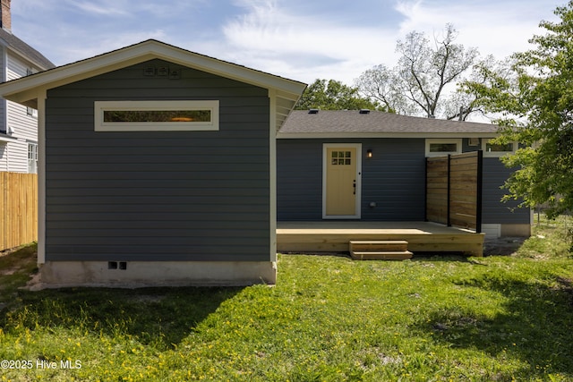 exterior space featuring fence, a wooden deck, and a front yard