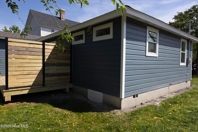 view of side of home featuring a lawn and crawl space