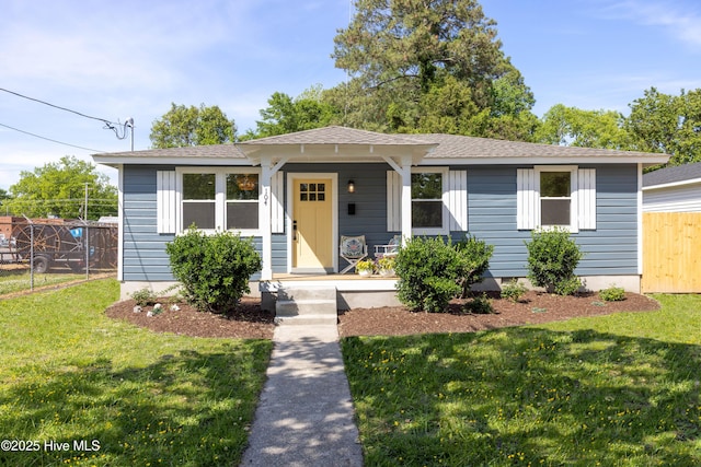 bungalow-style home with fence, a front yard, a shingled roof, and a porch