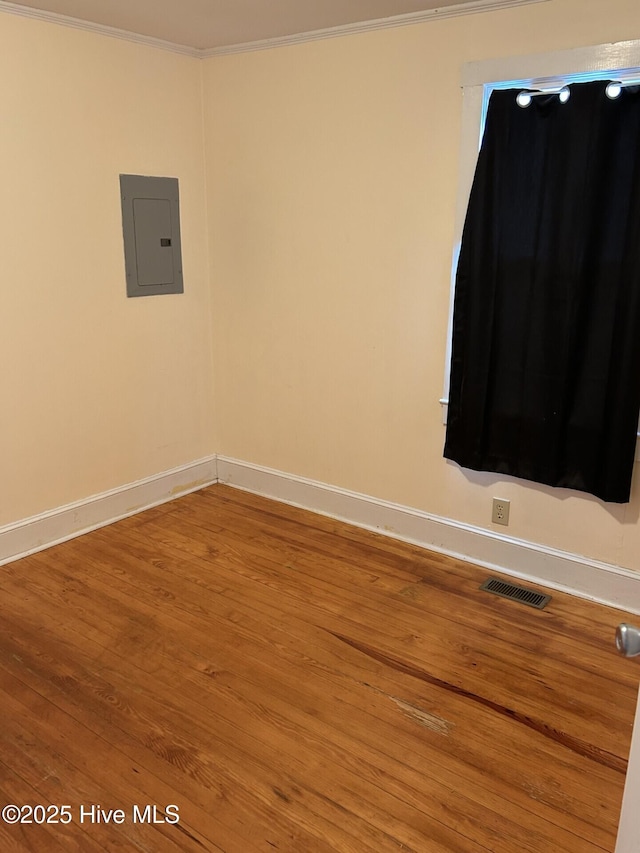 207 E Ashe St, Burgaw, NC 28425 - empty room with visible vents, electric panel, baseboards, ornamental molding, and wood finished floors