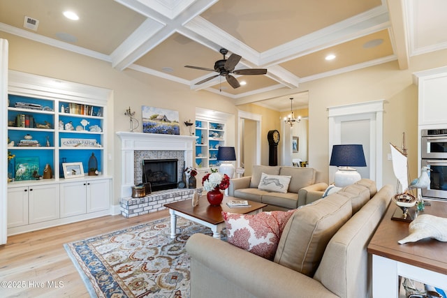 living area with light wood-type flooring, a fireplace, beam ceiling, coffered ceiling, and ornamental molding