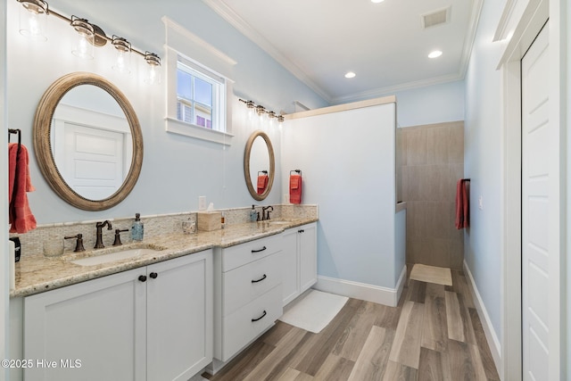 bathroom featuring double vanity, wood finished floors, crown molding, and a walk in shower