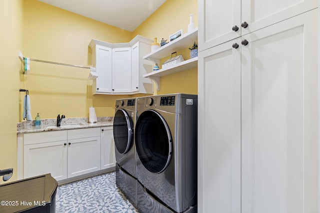 laundry area with washing machine and dryer, cabinet space, and light tile patterned floors