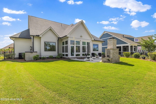 back of house with a patio area, roof with shingles, and a sunroom