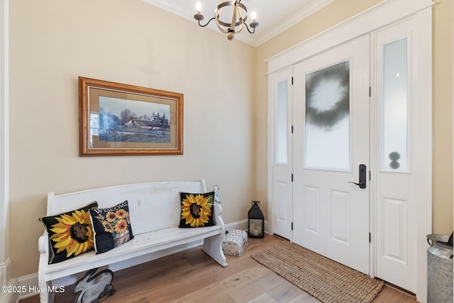 entryway featuring a chandelier, crown molding, light wood-style floors, and baseboards