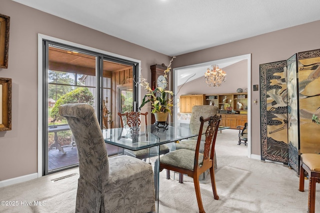 dining area featuring light colored carpet, baseboards, and a chandelier