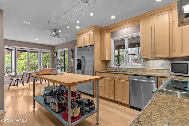 kitchen with stainless steel appliances, a sink, light brown cabinets, backsplash, and recessed lighting
