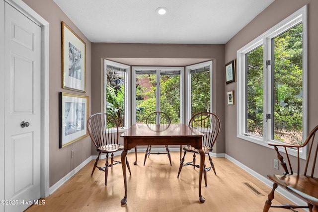 sunroom with baseboards, wood finished floors, and recessed lighting