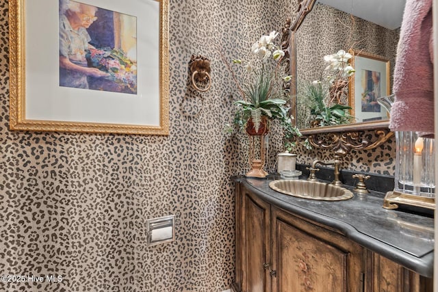 bathroom featuring wallpapered walls and vanity