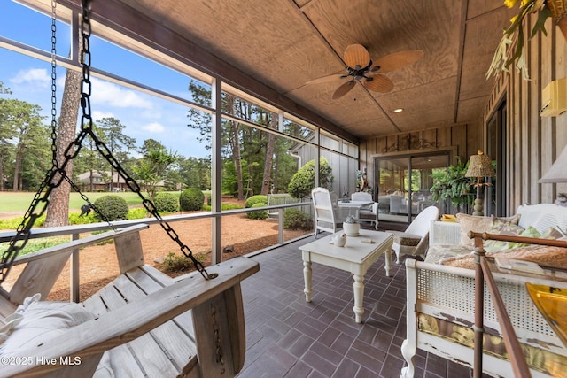 sunroom / solarium featuring a ceiling fan