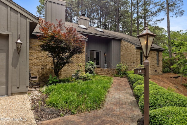 mid-century inspired home featuring a chimney and brick siding