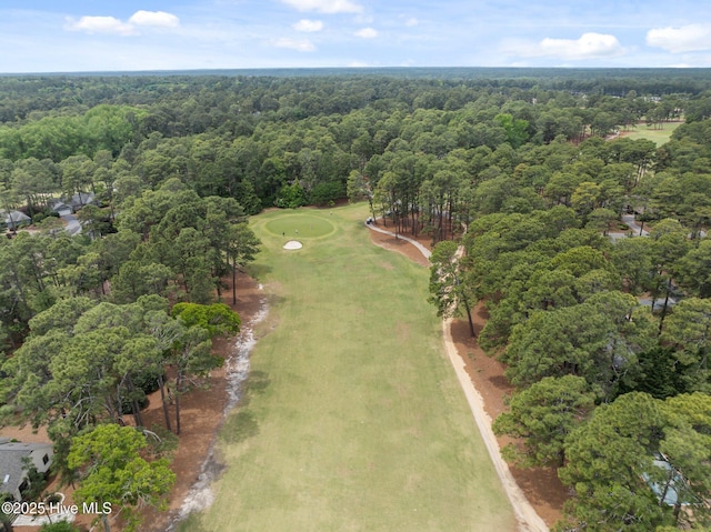 aerial view of property's location featuring a forest and a local golf course