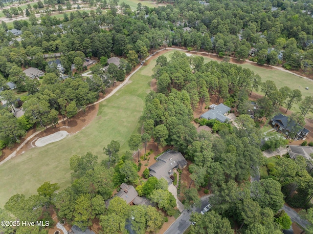 aerial view of property's location featuring nearby suburban area and a tree filled landscape