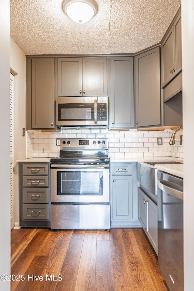 1100 Clarendon St Unit 606, Fayetteville, NC 28305 - kitchen featuring appliances with stainless steel finishes, gray cabinetry, a sink, light countertops, and dark wood-style flooring