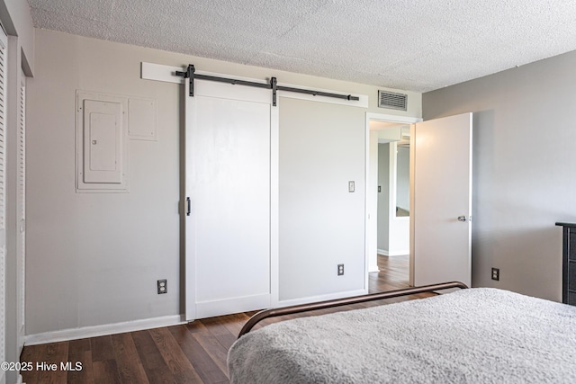 1100 Clarendon St Unit 606, Fayetteville, NC 28305 - bedroom with a barn door, wood finished floors, electric panel, a textured ceiling, and baseboards