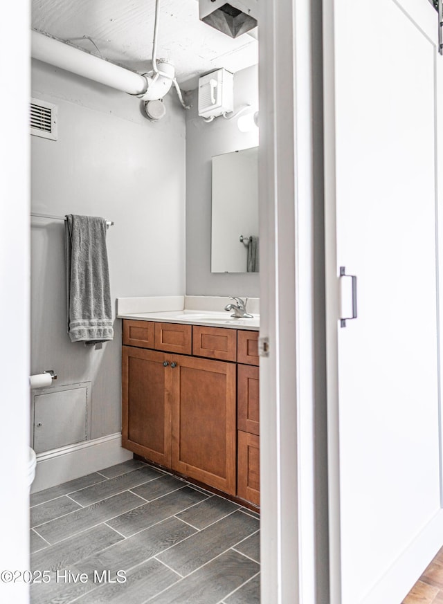 1100 Clarendon St Unit 606, Fayetteville, NC 28305 - bathroom with vanity, wood finish floors, baseboards, and toilet