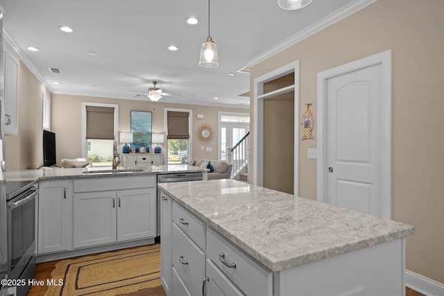 kitchen with electric range, a center island, a sink, open floor plan, and recessed lighting