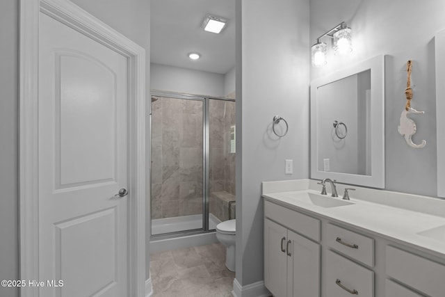 bathroom with double vanity, a sink, toilet, and a shower stall