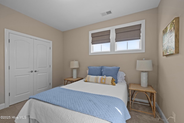 carpeted bedroom with baseboards, a closet, and visible vents