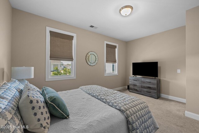 carpeted bedroom featuring baseboards and visible vents