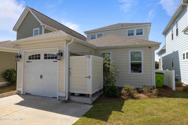 view of front facade with driveway, a shingled roof, a front lawn, and a garage