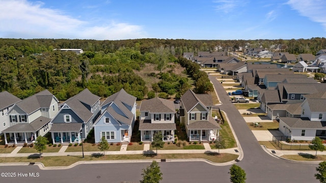 drone / aerial view featuring a wooded view and a residential view