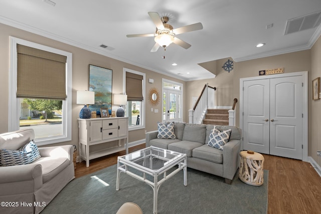 living area featuring visible vents, stairs, ceiling fan, and wood finished floors