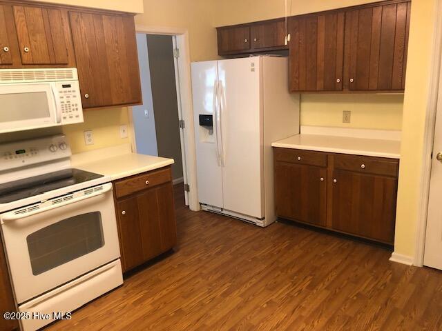 3443 Regency Dr, Wilmington, NC 28412 - kitchen featuring white appliances, light countertops, dark wood-style flooring, and dark brown cabinetry