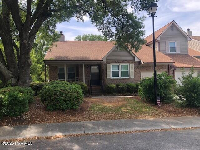 3443 Regency Dr, Wilmington, NC 28412 - ranch-style home with brick siding, an attached garage, and roof with shingles