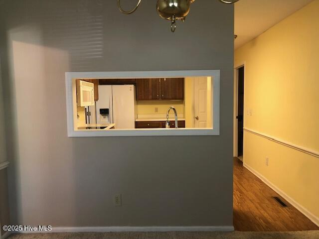 3443 Regency Dr, Wilmington, NC 28412 - kitchen with white refrigerator with ice dispenser, dark wood-style flooring, and a peninsula