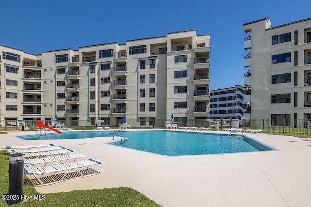 pool featuring fence and a patio area