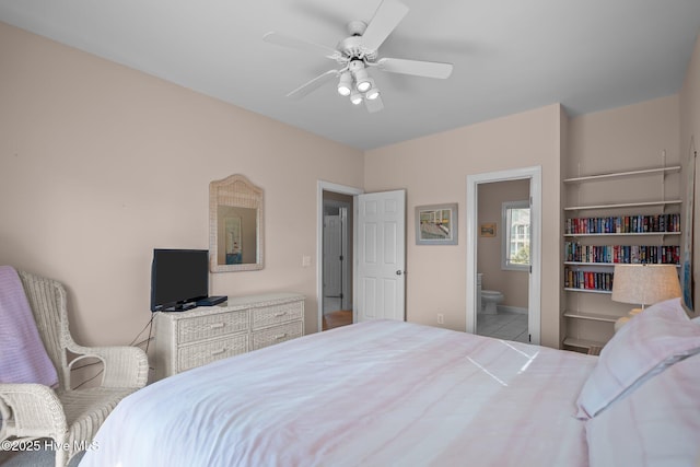 bedroom with tile patterned floors, connected bathroom, baseboards, and a ceiling fan