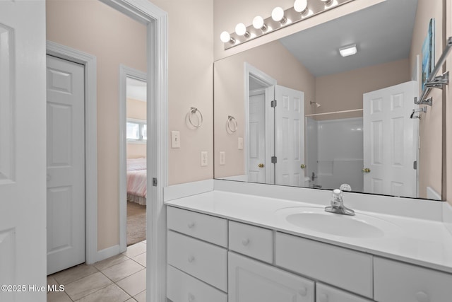 bathroom with tile patterned flooring, vanity, and a shower