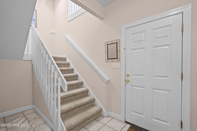 stairs featuring tile patterned flooring and baseboards
