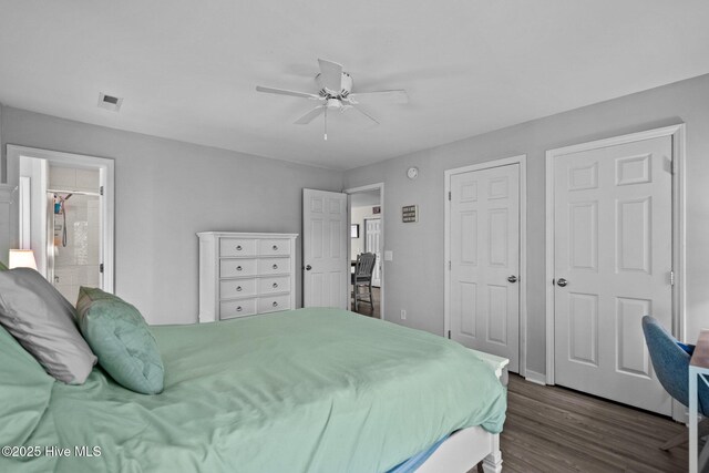 bedroom featuring dark wood-type flooring, ensuite bath, and a ceiling fan
