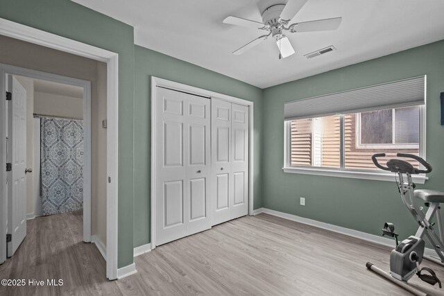 workout area featuring wood finished floors, a ceiling fan, and baseboards