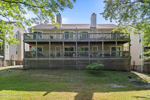 back of property with a yard, a deck, and a chimney