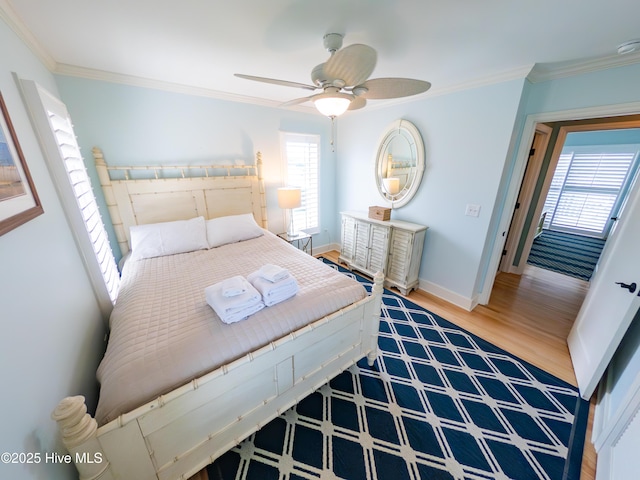 bedroom featuring ornamental molding, wood finished floors, baseboards, and ceiling fan