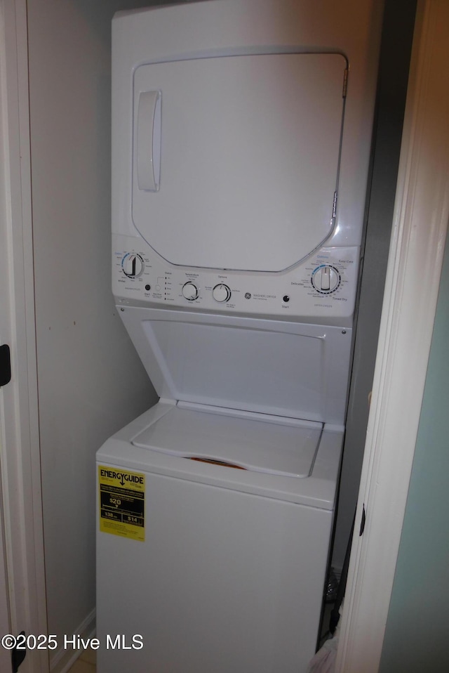 clothes washing area with stacked washing machine and dryer