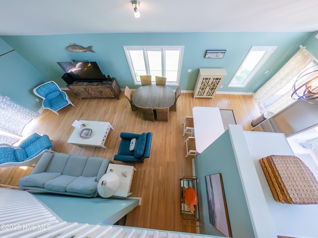 living area with a skylight and wood finished floors